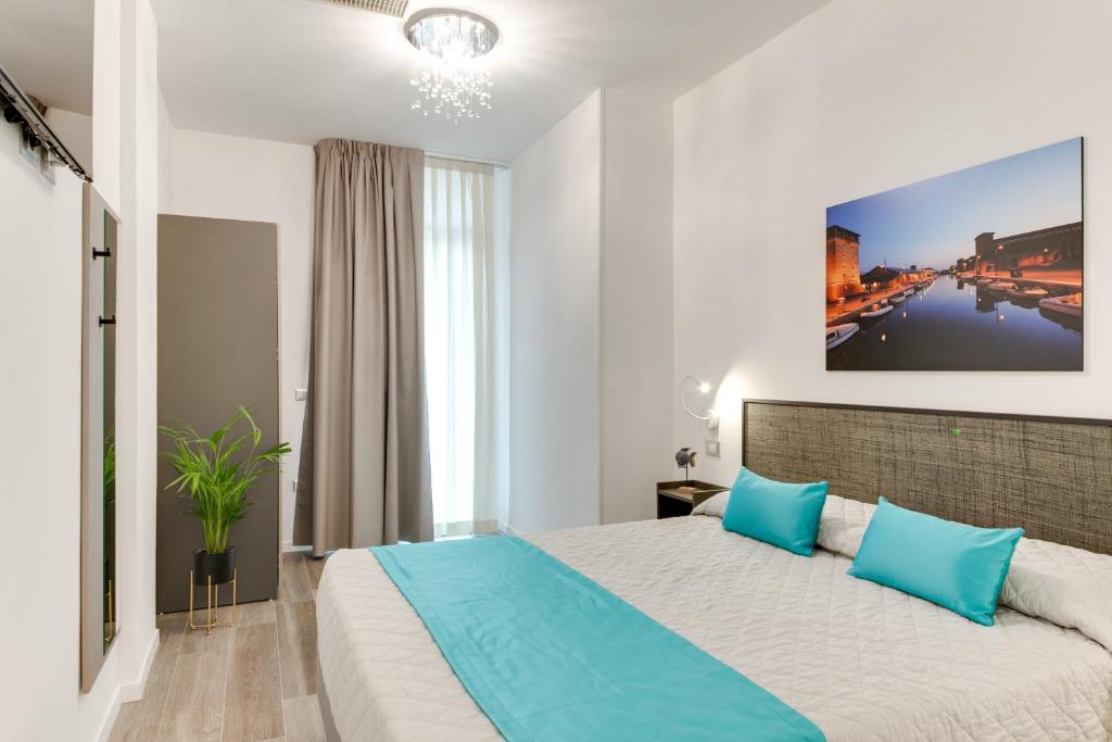 une chambre avec un grand lit avec des oreillers bleus dans l'établissement Elegance Suite Apartments - Siroli Collection, à Cervia
