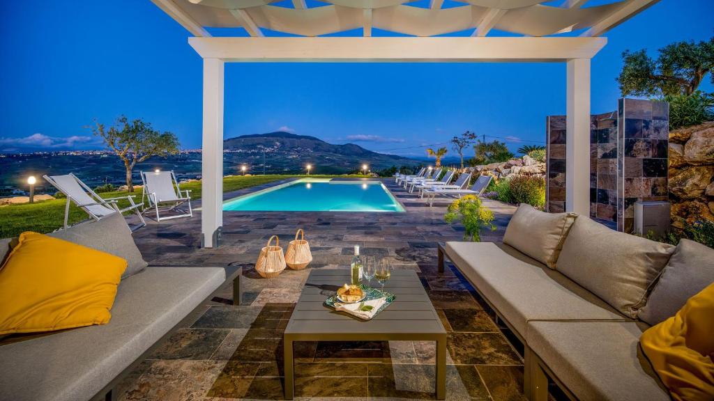 une terrasse avec un canapé, une table et une piscine dans l'établissement DAMA DEI VENTI 6&2, Emma Villas, à Castellammare del Golfo