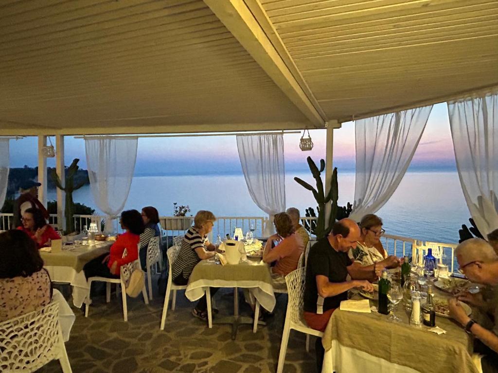 un groupe de personnes assises à des tables dans un restaurant dans l'établissement Mediterranean Boutique Hotel, à Tropea