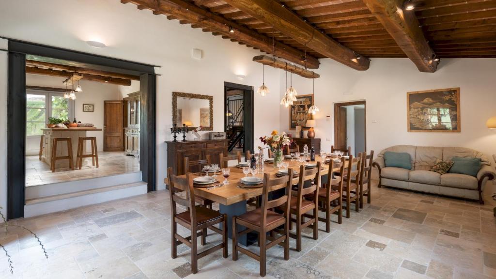 une salle à manger avec une grande table et des chaises en bois dans l'établissement LE COLOMBELLINE 12, Emma Villas, à Montepulciano