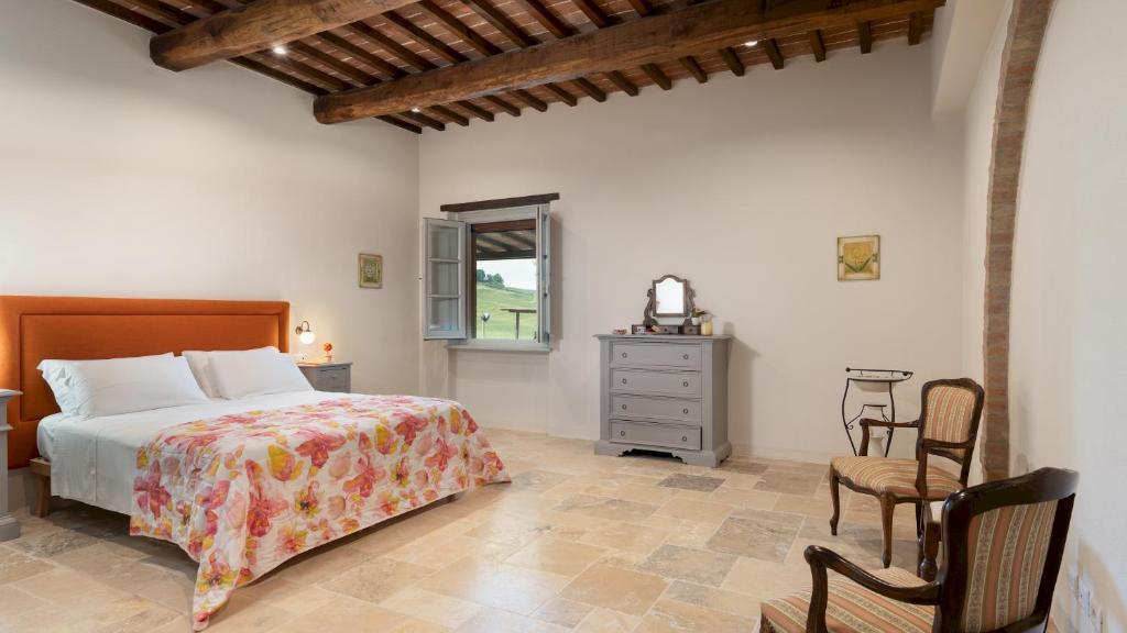 une chambre avec un lit, une table et des chaises dans l'établissement LE COLOMBELLINE 12, Emma Villas, à Montepulciano