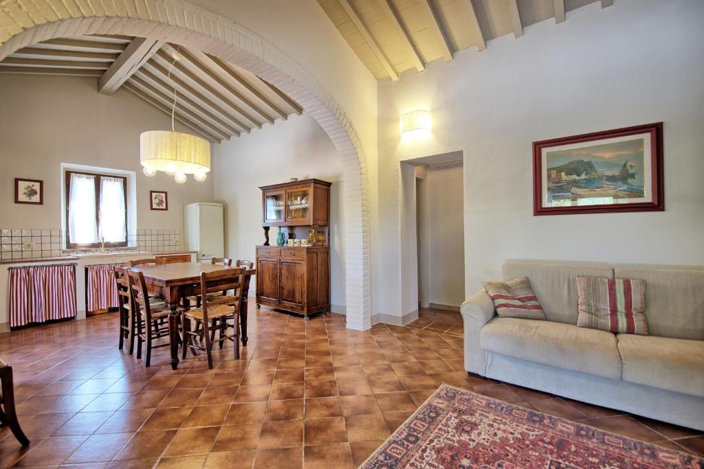 un salon avec un canapé, une table et des chaises dans l'établissement Cuccardino by PosarelliVillas, à Bibbona