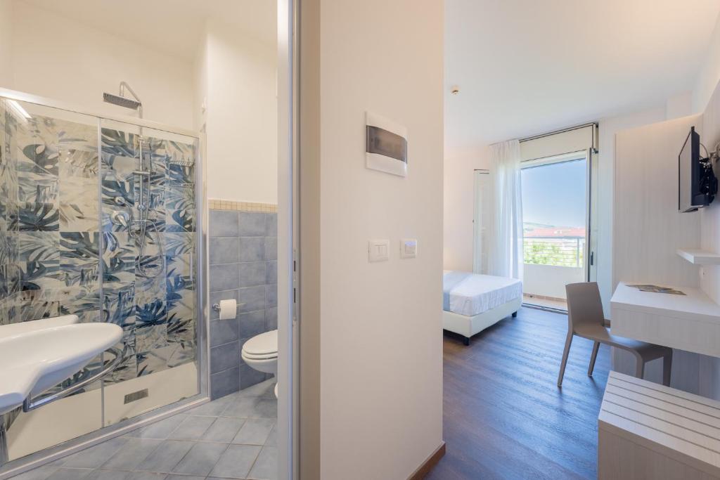 une salle de bain avec toilettes et lavabo dans l'établissement Hotel Corfù, à Pineto