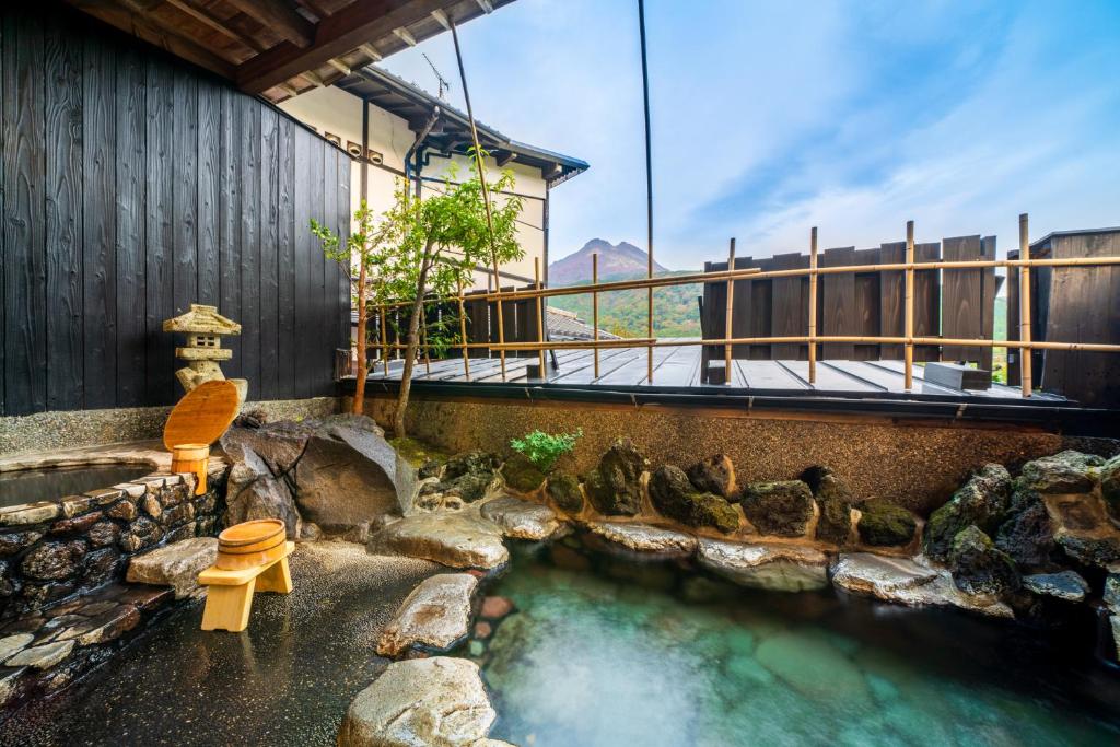 une source chaude avec un banc et quelques oiseaux dans l'eau dans l'établissement Yawaragi-no-Sato Yadoya, à Yufu