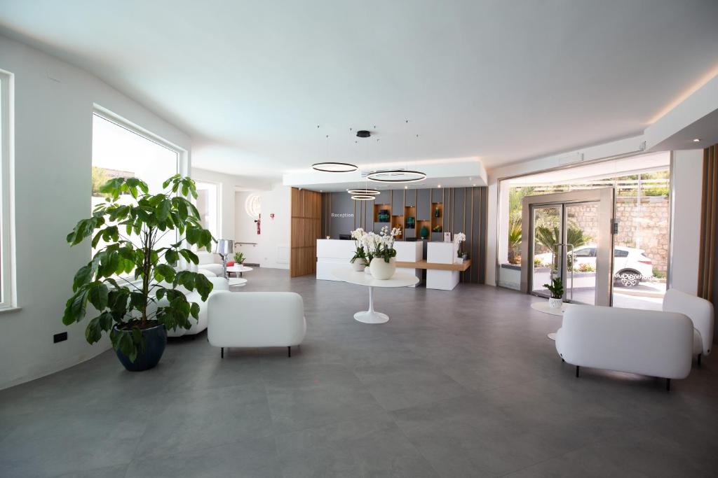 un salon avec des meubles blancs et des plantes dans l'établissement Hotel Sporting Club, à Altavilla Milicia 94 autres photos