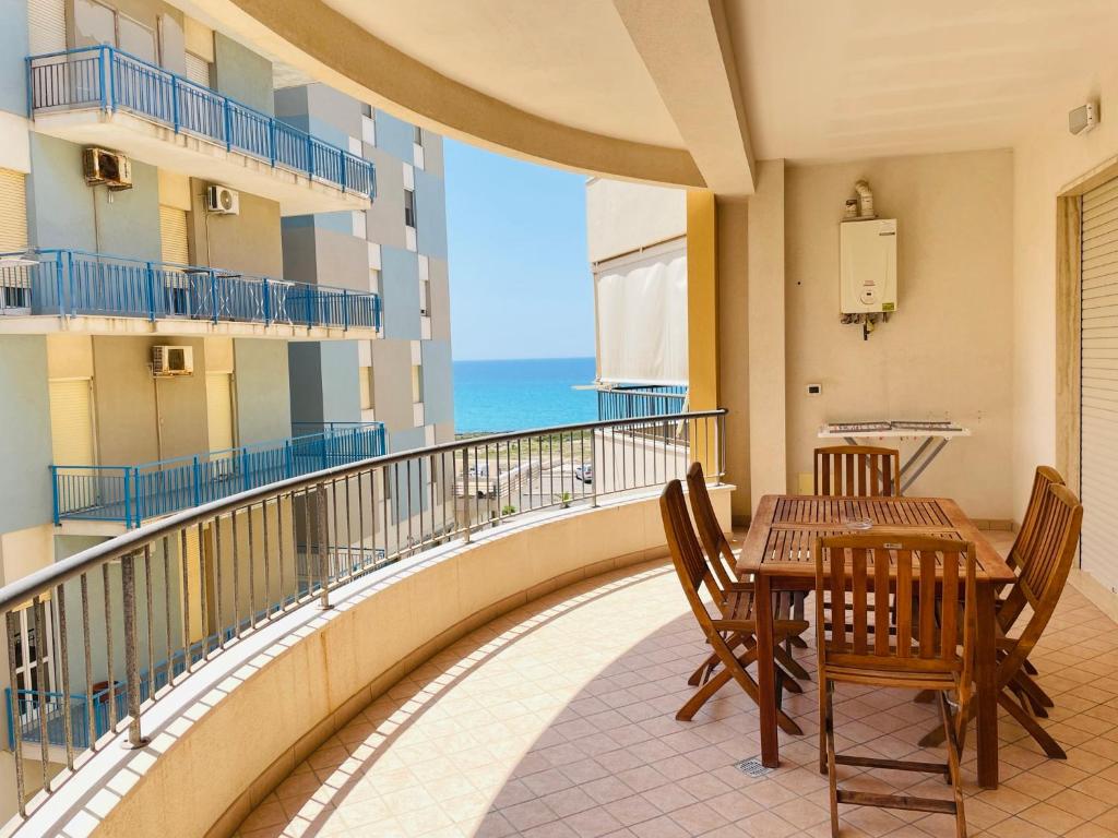 un balcon avec une table et des chaises et l'océan dans l'établissement Rosa Virginia Apartment, à Gallipoli