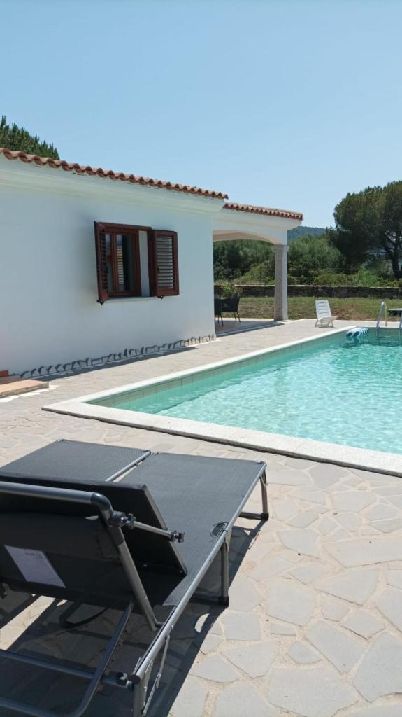 - une piscine avec une table à côté d'une maison dans l'établissement Villa Gallura Dream with private pool and sea view, à Tanaunella