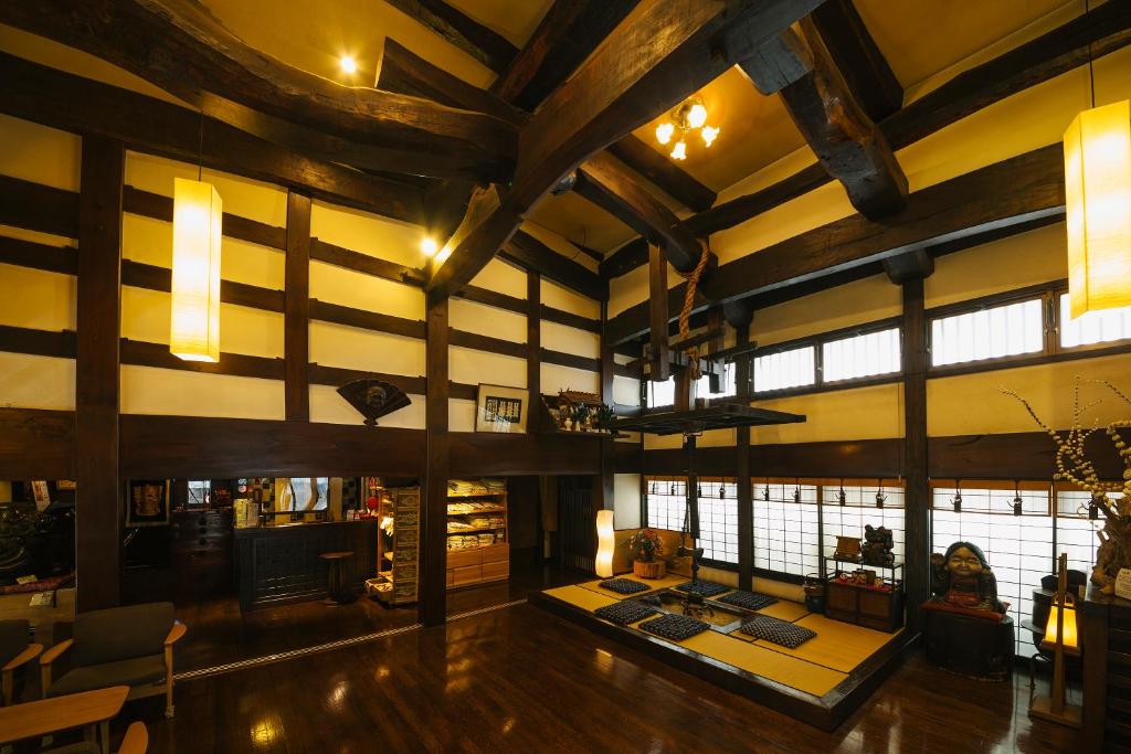 Cette grande chambre est dotée de plafonds en bois et de grandes fenêtres. dans l'établissement Ryokan Asunaro, à Takayama