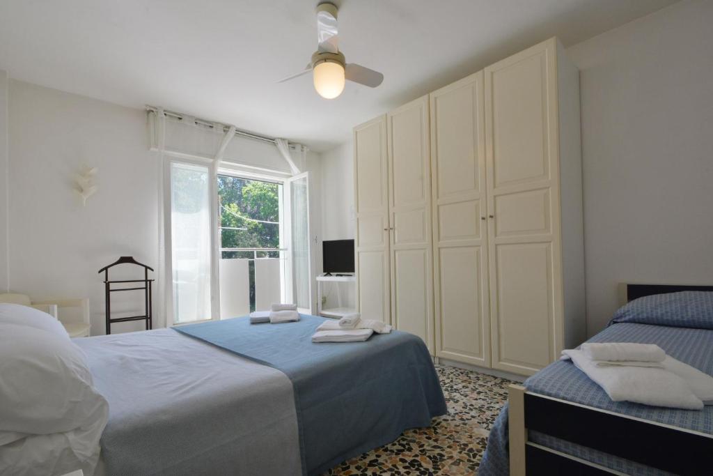 une chambre avec deux lits et une grande fenêtre dans l'établissement Hotel Maddalena, à Marina di Ravenna