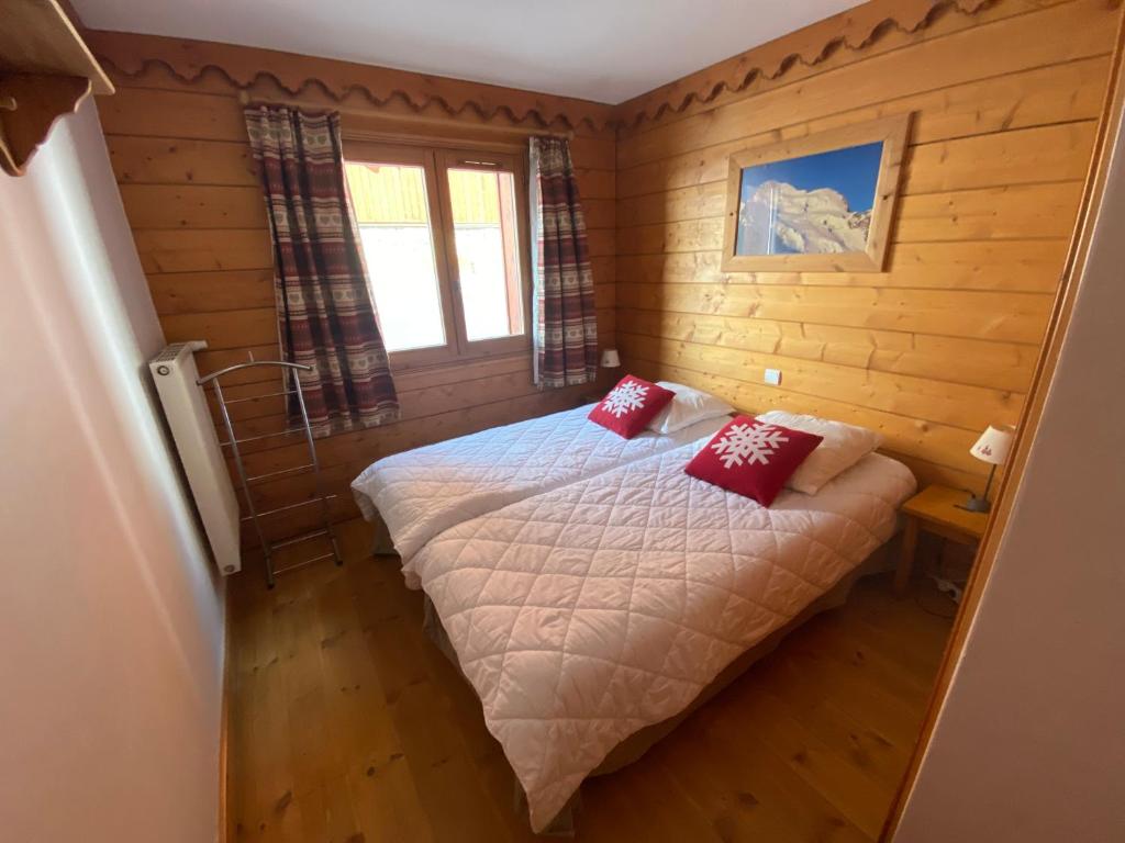 - une chambre avec un lit doté d'oreillers rouges dans l'établissement Tignes-8-10 personnes-4 chambres-parking, à Tignes