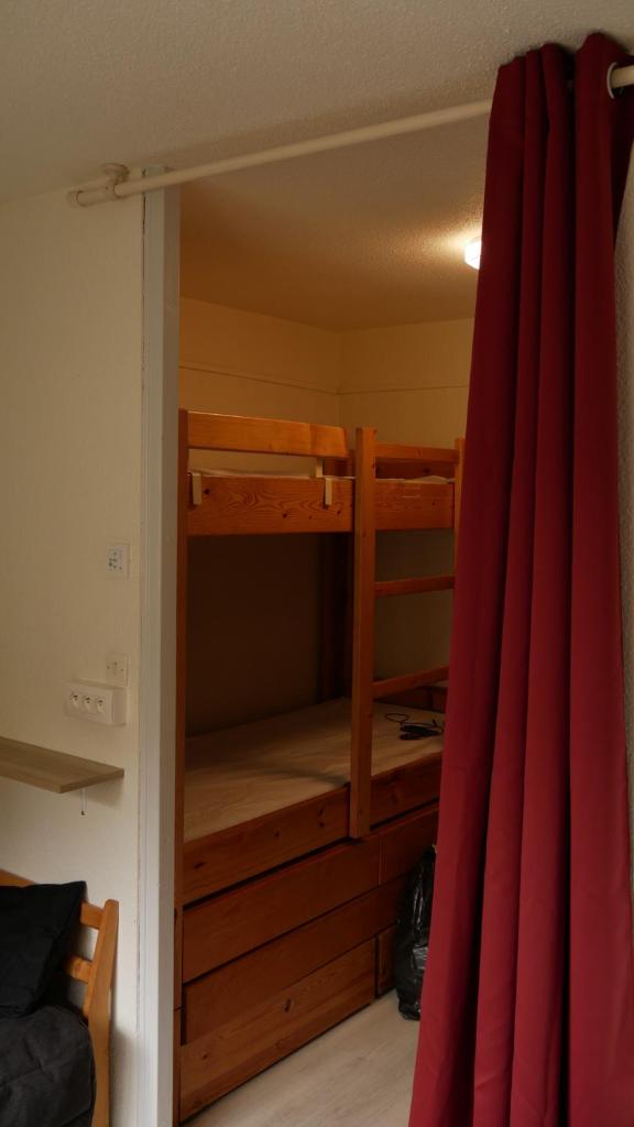 Ce lit superposé se trouve dans un dortoir doté d'un rideau rouge. dans l'établissement Studio Kandahar - Les 2 Alpes, à Les Deux Alpes