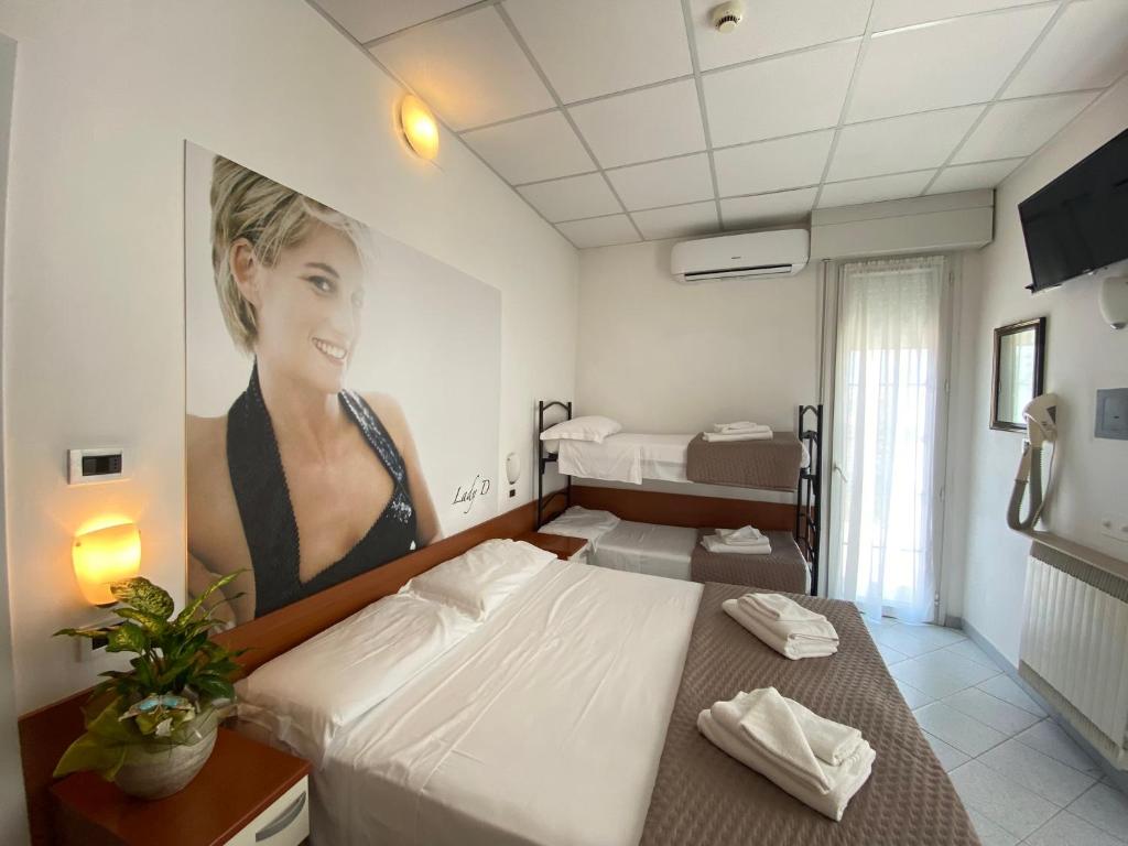 une chambre avec un lit et une peinture d'une femme dans l'établissement Hotel Villa del Parco, à Rimini