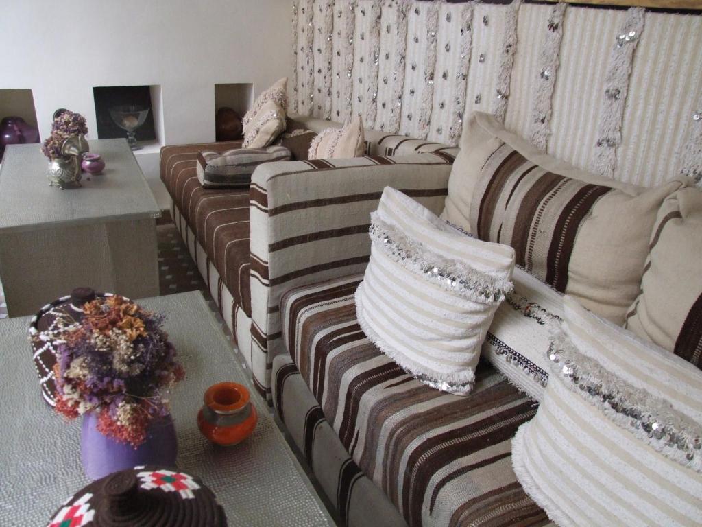 un canapé avec des coussins dessus dans un salon dans l'établissement Dar Charkia, à Marrakech
