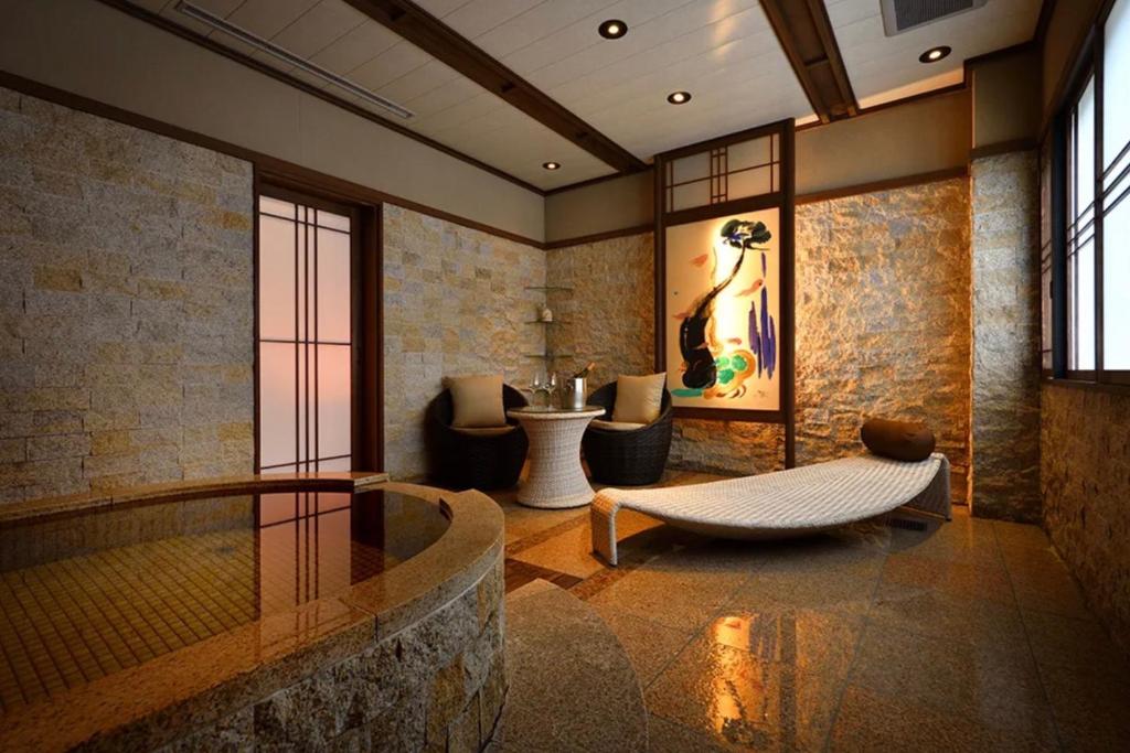 un salon avec un canapé et une table dans l'établissement Shima Onsen Yoshimoto, à Nakanojo