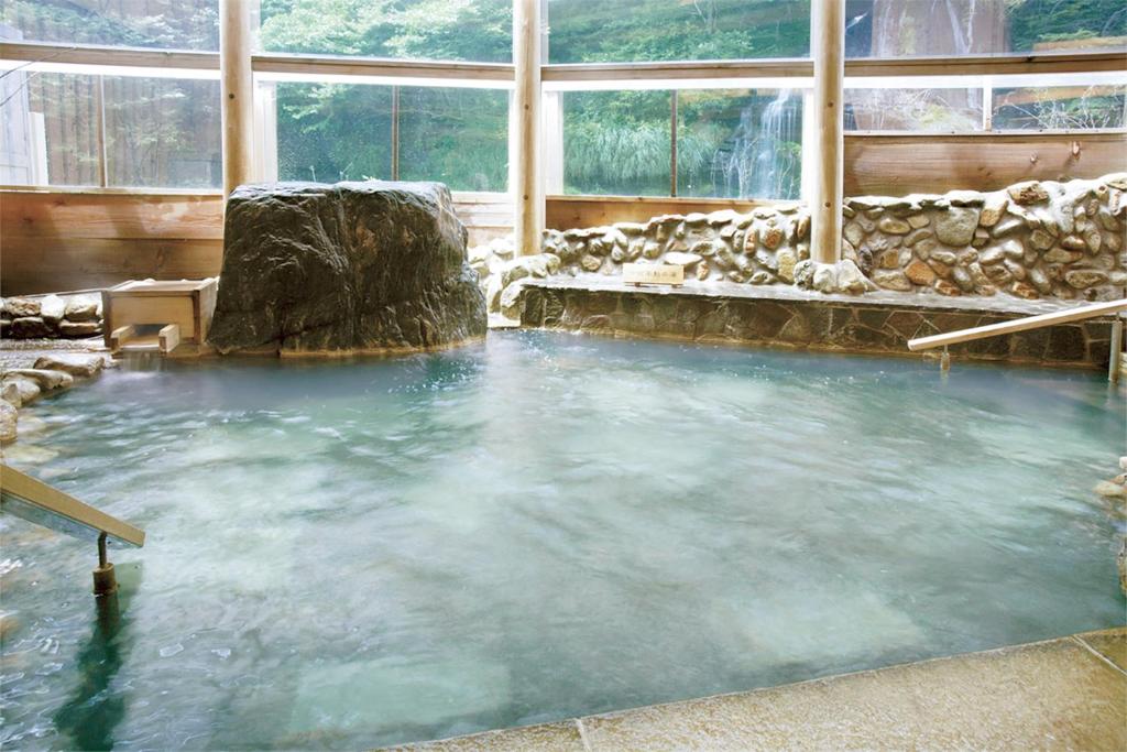 - une grande piscine d'eau dans une chambre avec fenêtres dans l'établissement Ooedo Onsen Monogatari Premium Hotel New Shiobara, à Nasushiobara