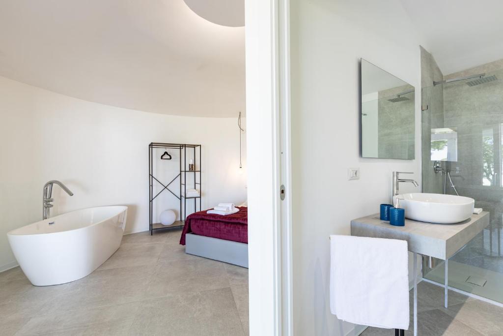 une salle de bain blanche avec deux lavabos et un miroir dans l'établissement Baia del Sole Resort, à Olbia