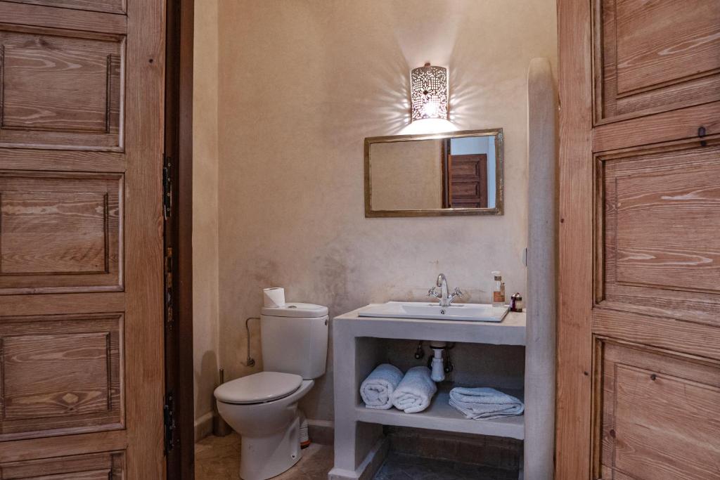 une salle de bain avec toilettes, lavabo et miroir dans l'établissement Riad Le Plein Sud, à Marrakech 37 autres photos