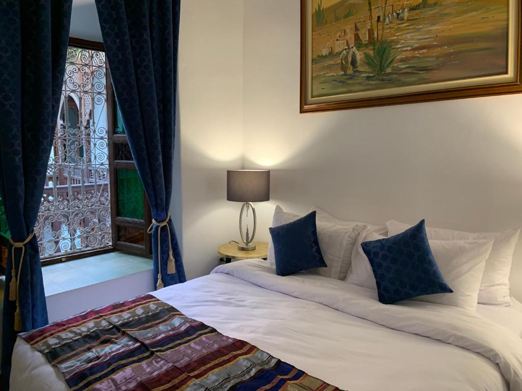 - une chambre avec un lit doté de rideaux bleus et d'une fenêtre dans l'établissement Riad Malida Marrakech, à Marrakech 36 autres photos