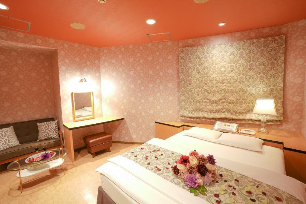 - une chambre avec un grand lit fleuri dans l'établissement Hotel Jupiter (Adult Only), à Hiroshima