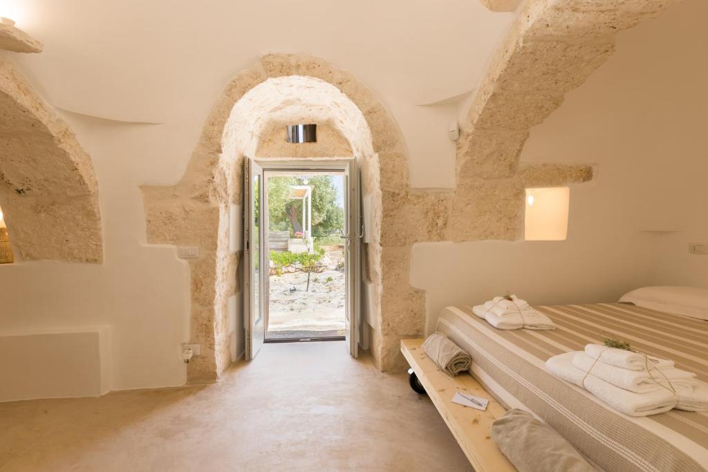 - une chambre avec 2 lits et une porte voûtée dans l'établissement New Villa Filara with Sea view Pool, à Specchiolla