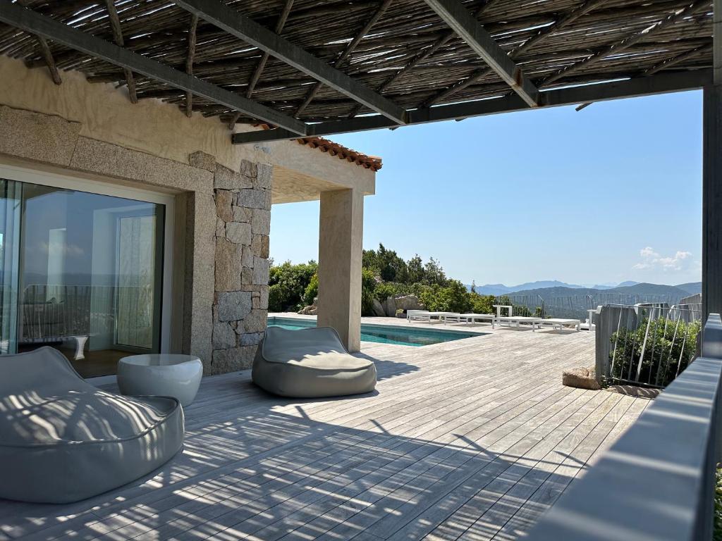 un patio avec des chaises et une piscine dans l'établissement Villa with pool and panoramic view Costa Smeralda, à Abbiadori