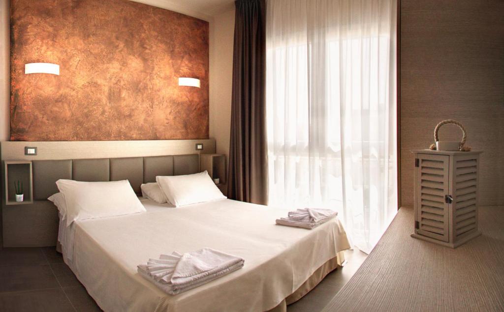 une chambre avec un lit et une grande fenêtre dans l'établissement Hotel Helvetia, à Lido di Jesolo