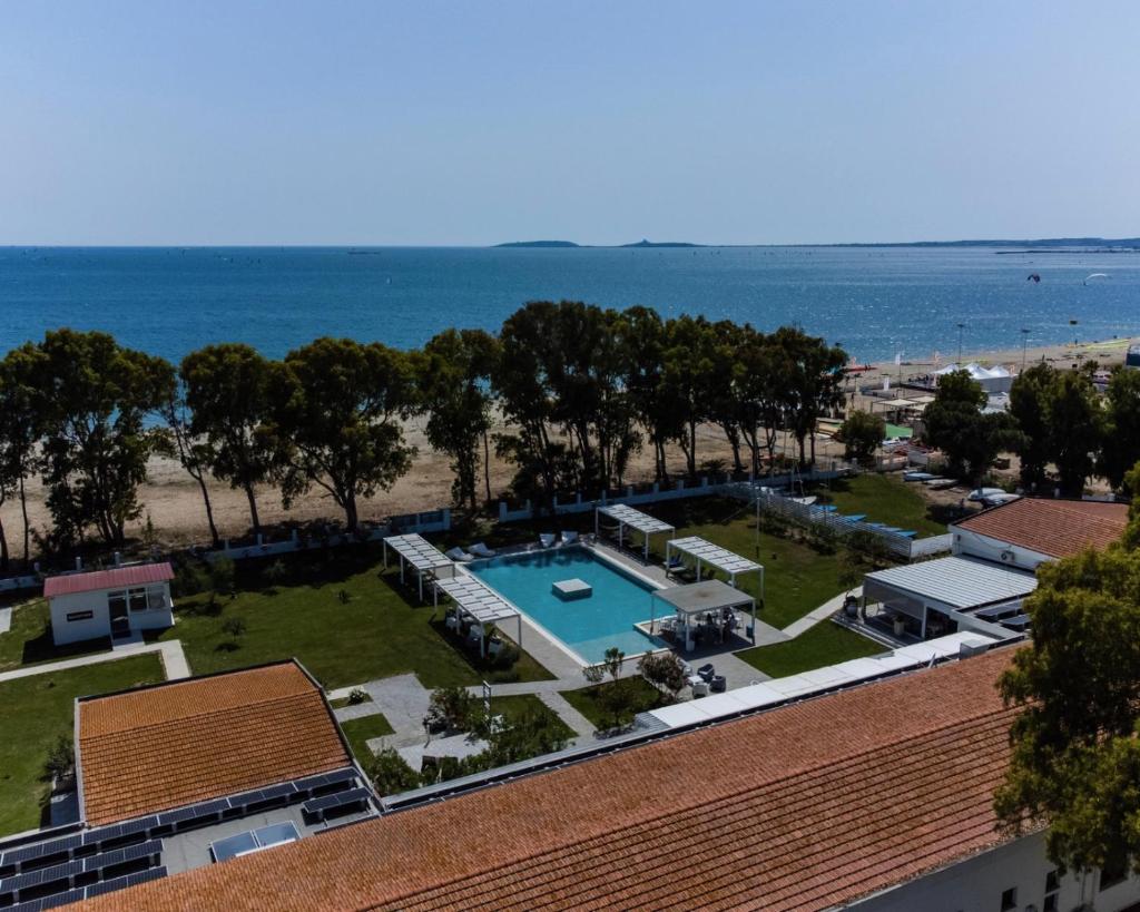 une vue aérienne d'un complexe hôtelier avec piscine et plage dans l'établissement Hotel Lido Beach PHG, à Oristano