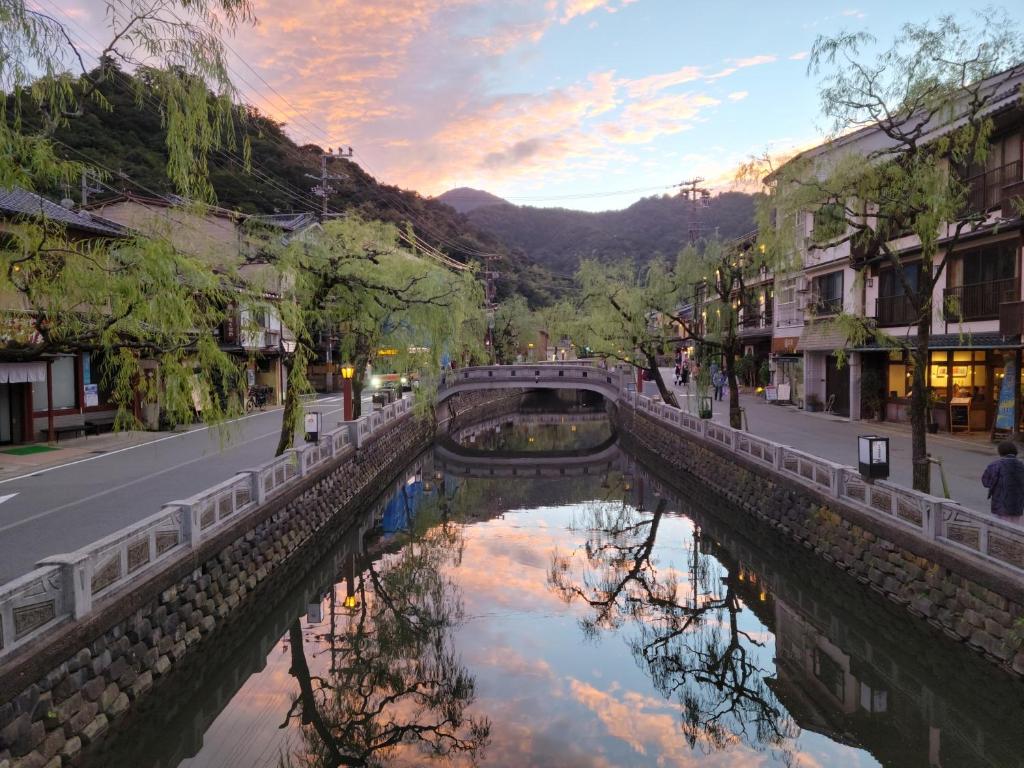 un pont sur une rivière à côté d'une rue dans l'établissement Tsukimotoya Ryokan, à Toyooka