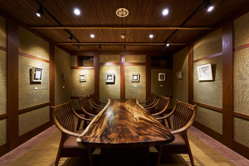 une salle de conférence avec une table et des chaises en bois dans l'établissement Shima-Onsen Toshimaya, à Nakanojo 194 autres photos