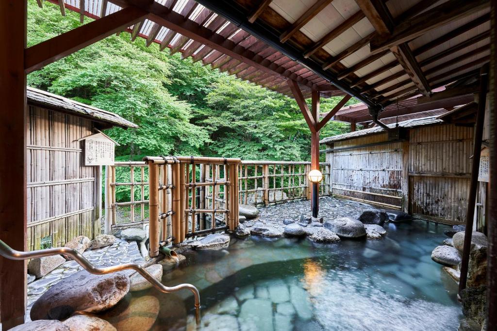 une flaque d'eau dans un bâtiment avec une clôture dans l'établissement Shima-Onsen Toshimaya, à Nakanojo