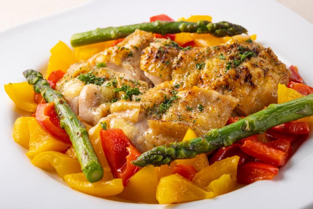 une assiette blanche de nourriture avec du poulet et des légumes dans l'établissement Hotel Taikan, à Morioka 37 autres photos