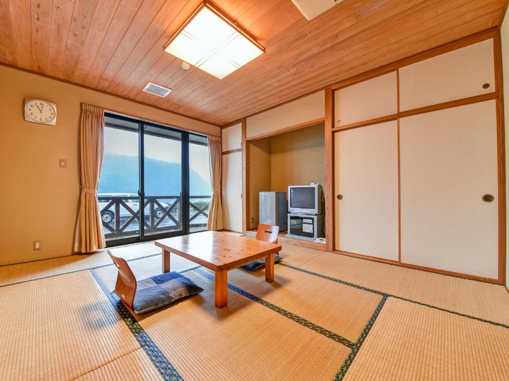 un salon avec une table et une grande fenêtre dans l'établissement 守実温泉　やすらぎの郷やまくに, à Morizane 50 autres photos