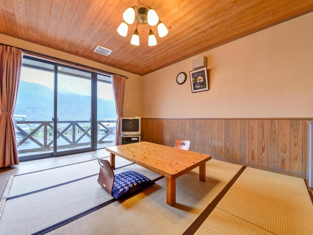 une salle à manger avec une table et une grande fenêtre dans l'établissement 守実温泉　やすらぎの郷やまくに, à Morizane