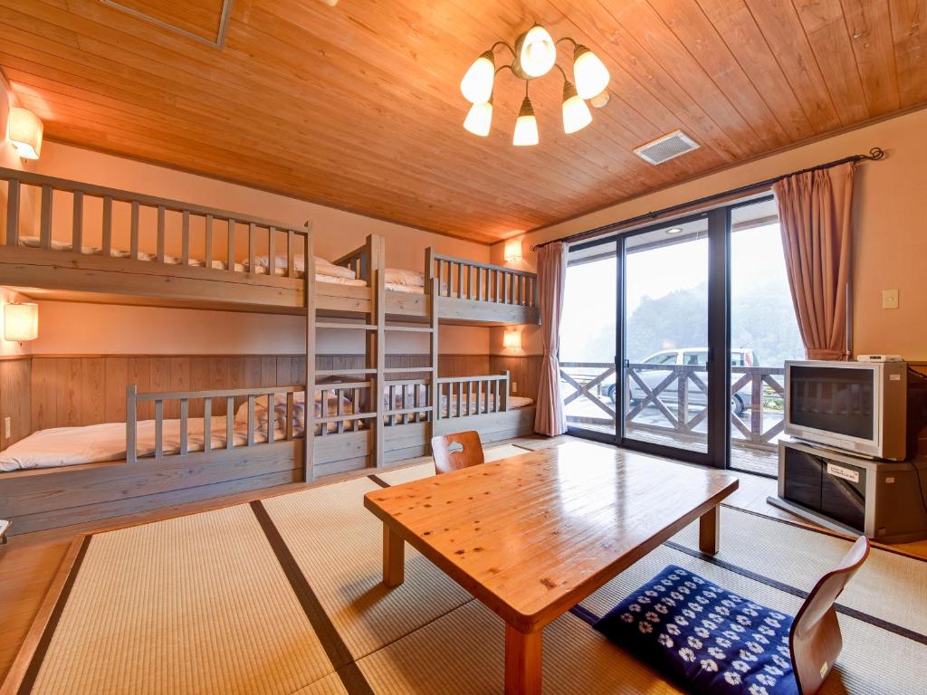 - un salon avec des lits superposés et une table dans l'établissement 守実温泉　やすらぎの郷やまくに, à Morizane