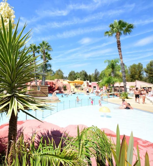 une grande piscine avec des gens dans un complexe hôtelier dans l'établissement Mobil Home Hyères les palmiers, à Hyères