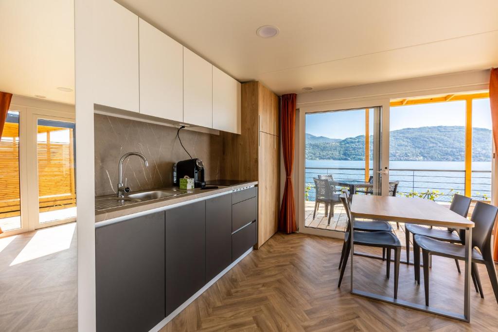 une cuisine avec une table et une salle à manger avec vue dans l'établissement Lago Maggiore Bay, à Baveno