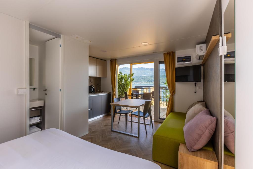 une chambre avec un lit et une cuisine avec une table dans l'établissement Lago Maggiore Bay, à Baveno