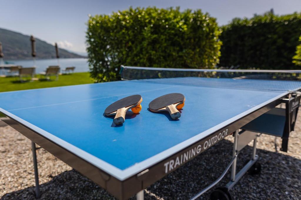 une table de ping-pong avec deux raquettes de tennis dessus dans l'établissement Lago Maggiore Bay, à Baveno