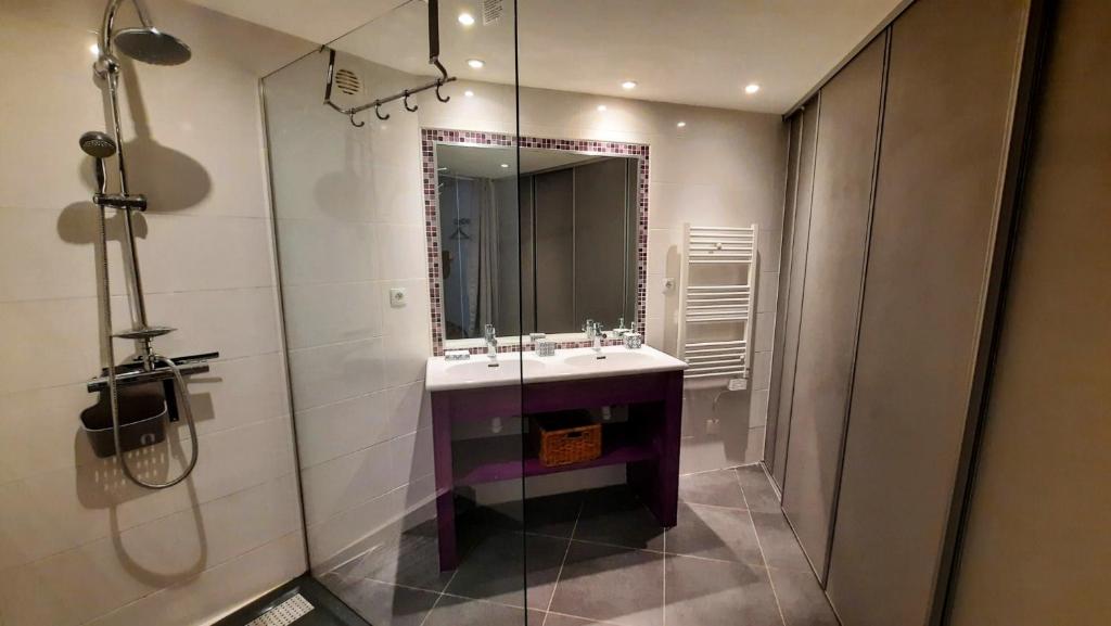 une salle de bain avec un lavabo et un miroir dans l'établissement Gîte avec piscine et jacuzzi partagés en Cévennes, à Cros