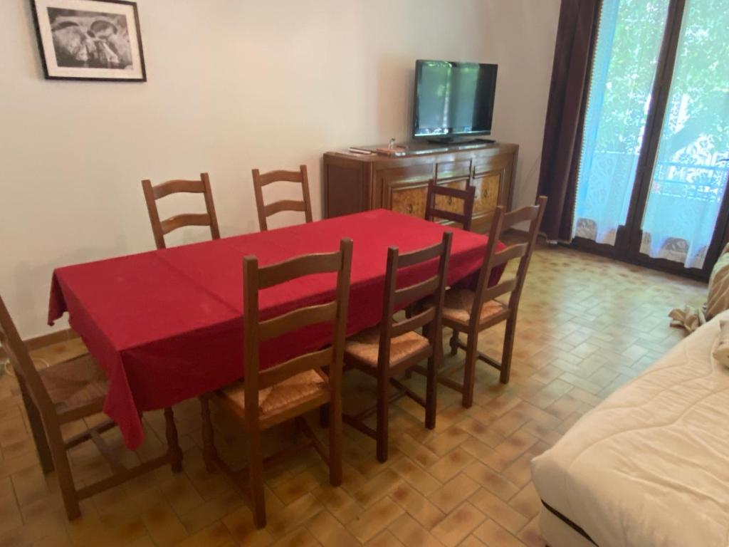 une salle à manger avec une table et des chaises rouges dans l'établissement NOUVEAU Maison de la place, à Jaujac