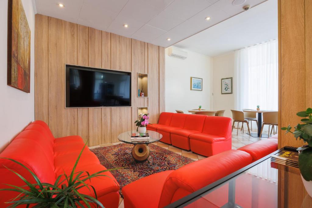 Il comprend un salon doté d'un mobilier rouge et d'une télévision à écran plat. dans l'établissement Hotel Jalisco, à Lido di Jesolo