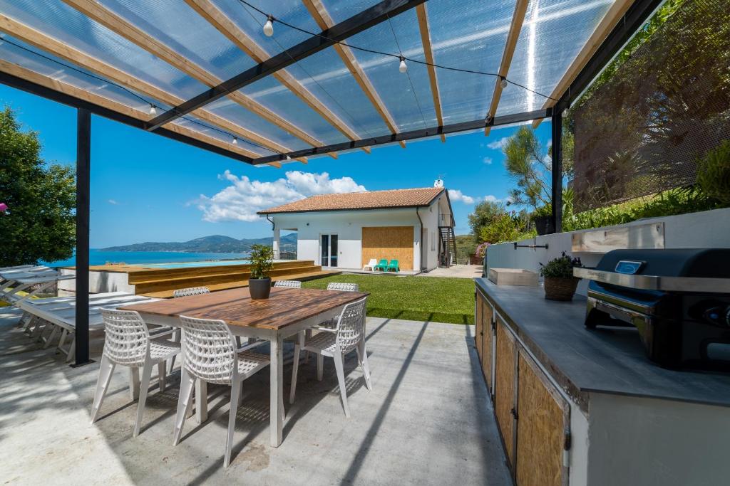 un patio extérieur avec une table et des chaises en bois dans l'établissement Naima Boutique Villa, à Ascea