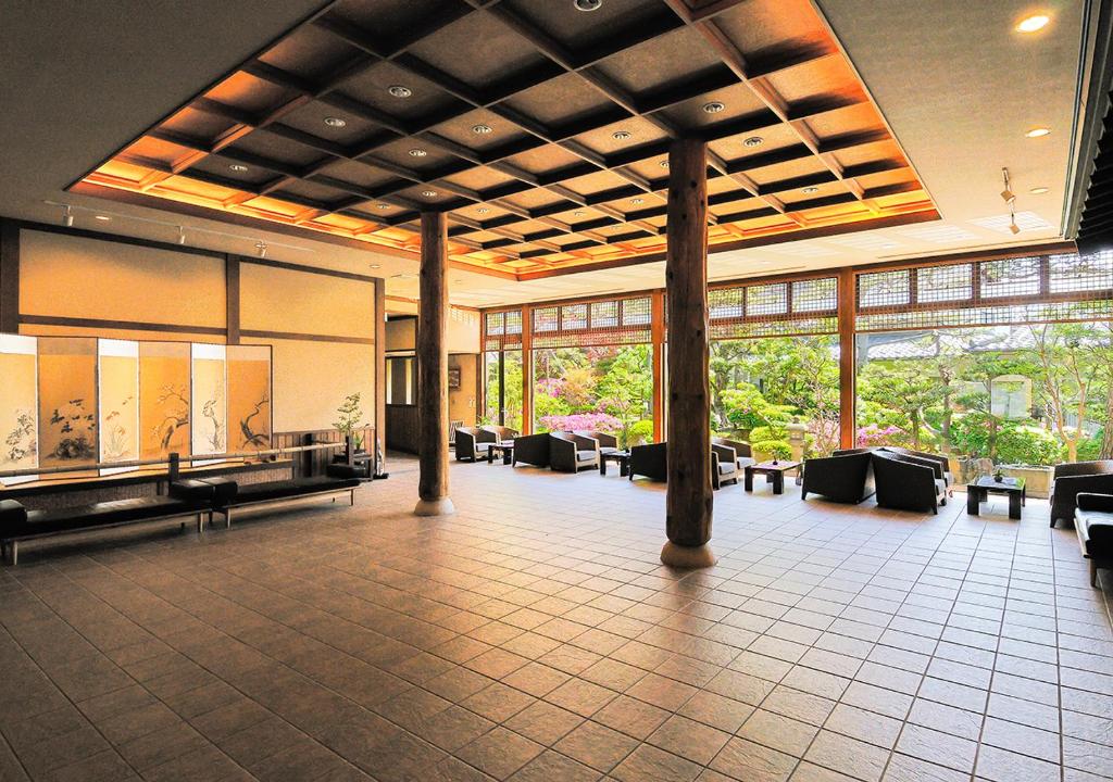 - un grand hall avec des tables, des chaises et des fenêtres dans l'établissement Haiya, à Awara