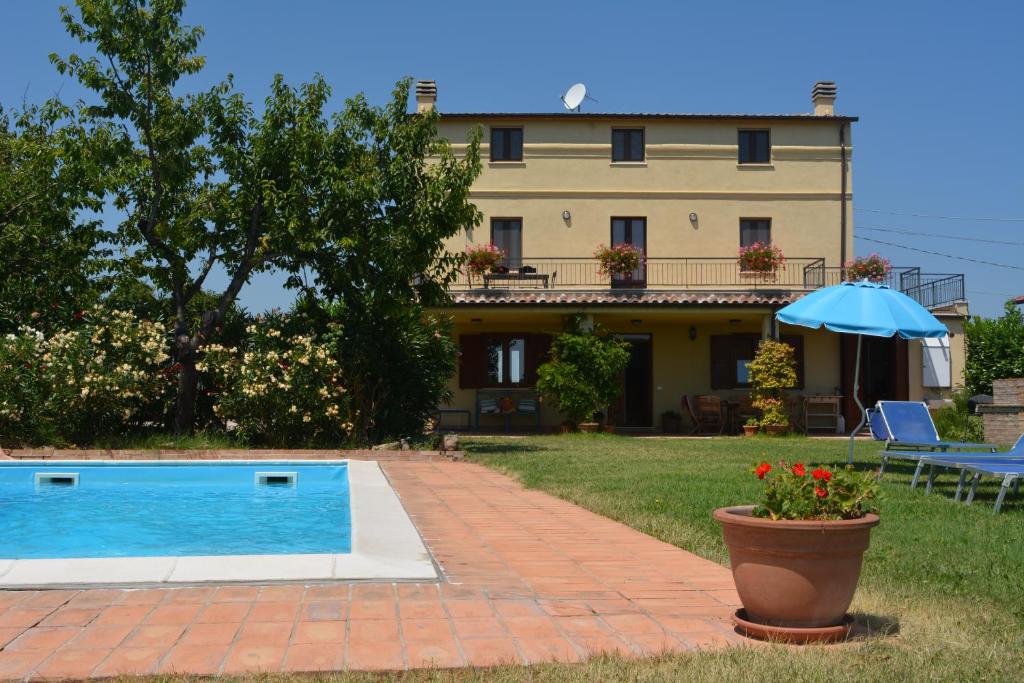 une maison avec une piscine et un parasol dans l'établissement Casa Trastulli, à Castelfrentano