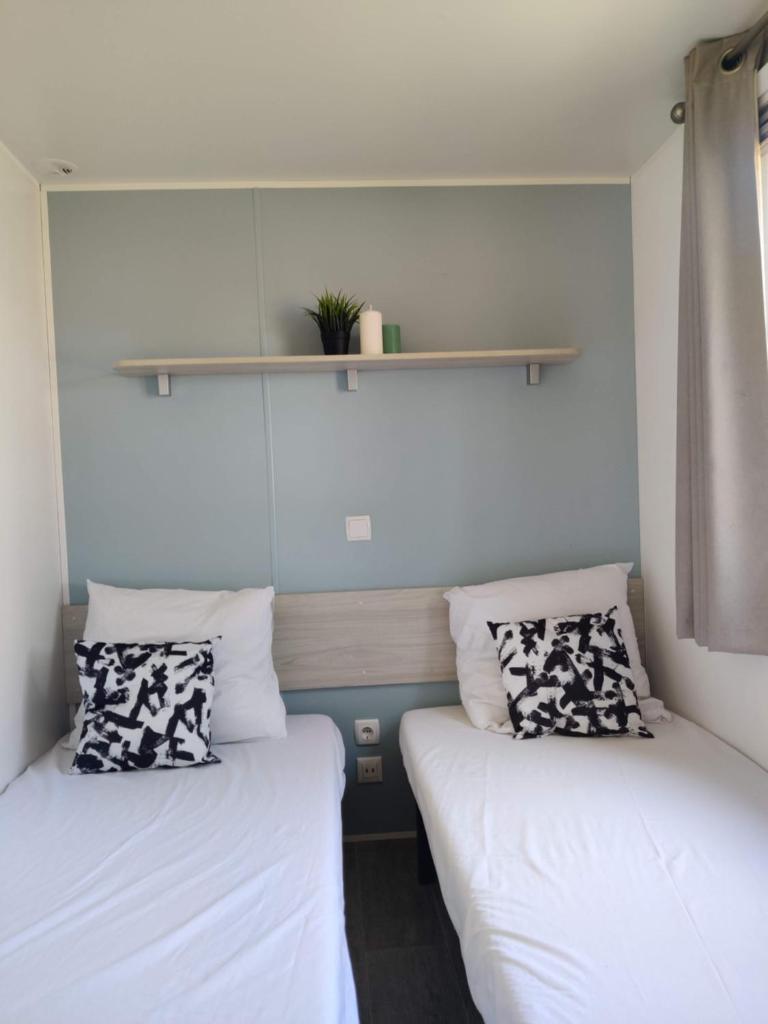 deux lits côte à côte dans une pièce dans l'établissement Mobil Home 6/8 personnes Camping le lac des rêves, à Lattes