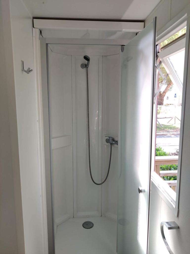 une douche dans une salle de bain avec une porte vitrée dans l'établissement Mobil Home 6/8 personnes Camping le lac des rêves, à Lattes
