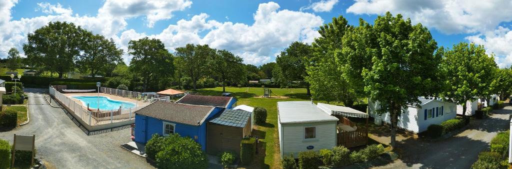 une vue aérienne d'une maison et d'une piscine dans l'établissement CAMPING LES EMBRUNS 3*, à Camoël