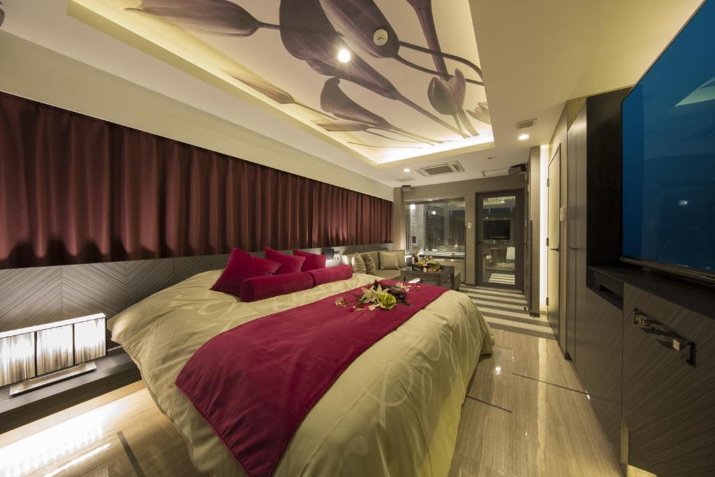 une chambre avec un grand lit avec des oreillers rouges dans l'établissement Hotel In The Green (Adult Only), à Kyoto 22 autres photos