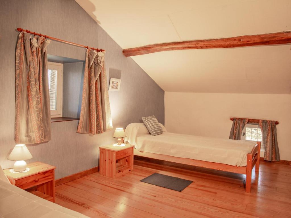 - une chambre avec 2 lits, 2 tables et un miroir dans l'établissement Gite Girou Haut, à Montcabrier