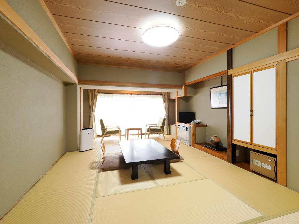un salon avec une table et des chaises dans l'établissement Ryokan Tamagoyu, à Machi-niwasaka
